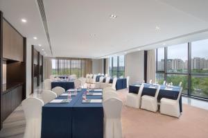 a conference room with blue tables and white chairs at Holiday Inn Ningbo Xiangshan Damu Bay by IHG in Xiangshan