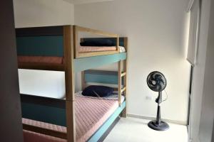 圣玛尔塔The Refuge#2 Lovely 2 BR-Apt pool & good vibes的带风扇的客房内的两张双层床