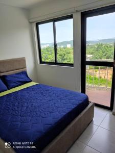 圣玛尔塔The Refuge#2 Lovely 2 BR-Apt pool & good vibes的带蓝色床和窗户的卧室