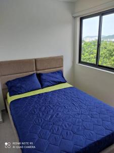 圣玛尔塔The Refuge#2 Lovely 2 BR-Apt pool & good vibes的一间卧室配有一张蓝色的床和窗户 更多23张照片