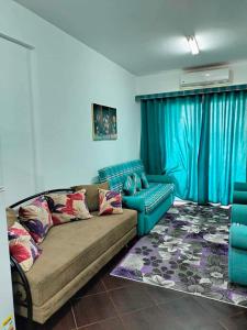 - un salon avec un canapé et un mur bleu dans l'établissement Porto Matroh ViP Spechial, à Marsa Matruh