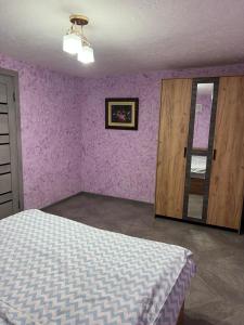 久姆里21 Street guest house的卧室设有紫色墙壁、床和门