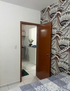 a room with a door leading to a kitchen at Quarto Super King com Ar in Imperatriz