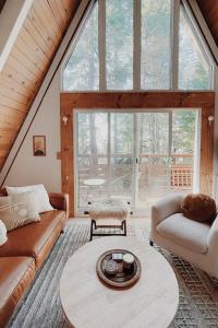 una sala de estar con un sofá y una mesa en A-Frame Cabin in The Woods, Close to Shops!, en Lake Arrowhead