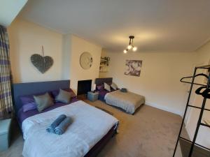 a bedroom with two beds and a couch at Large 4 bedrooms golders green in London