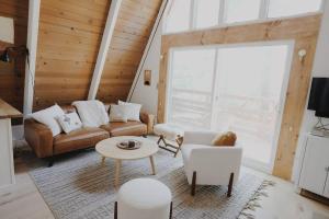 Una sala de estar con un sofá y sillas y una mesa. en A-Frame Cabin in The Woods, Close to Shops!, en Lake Arrowhead