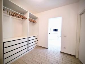 a walk in closet with white walls and a glass door at Sanremo Suite Apartment in Sanremo