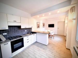 a kitchen with white cabinets and a table in it at Sanremo Suite Apartment in Sanremo +11 photos