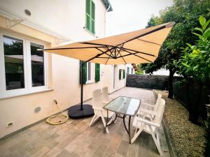 a patio with a table and chairs and an umbrella at Sanremo Suite Apartment in Sanremo