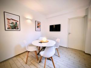 a dining room with a white table and chairs at Sanremo Suite Apartment in Sanremo