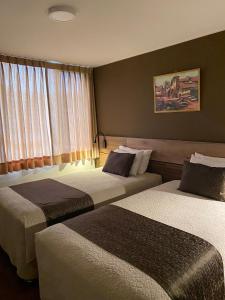 アレキパにあるVilla San Joséのベッド2台と窓が備わるホテルルームです。