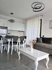 a living room with a white table and a couch at Sonely Apartament Shengjin in Shëngjin +5 photos