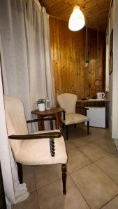 Una sala de estar con dos sillas y una mesa. en Room and suite Trinacria View, en Catania