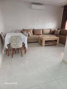 a living room with a couch and a table at Appartement entier avec piscine in Mohammedia