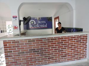 a woman standing at the counter of a hotel colonial at HOTEL COLONIAL in Barrancabermeja
