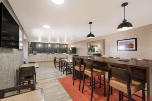 a kitchen and dining room with a bar and chairs at Best Western Bellemont Shadow Mountain Inn in Flagstaff