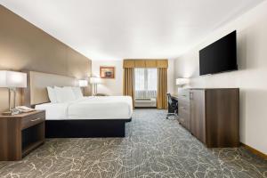a hotel room with a bed and a flat screen tv at Best Western West Towne Suites in Madison +46 photos