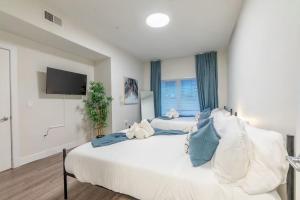 a large white bedroom with two beds and a tv at Blue Breakaway with Free Parking and Sleeps 9, Book 7 days, Get 20 Percent OFF in East Orange