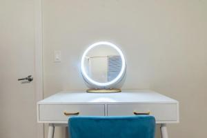 a mirror on top of a white dresser with a blue chair at Blue Breakaway with Free Parking and Sleeps 9, Book 7 days, Get 20 Percent OFF in East Orange