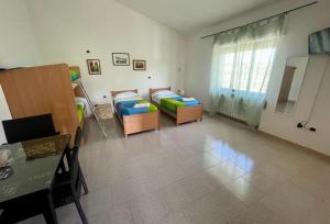 - un salon avec deux lits et une table dans l'établissement IL GLICINE CAMPAGNOLO, à Atessa