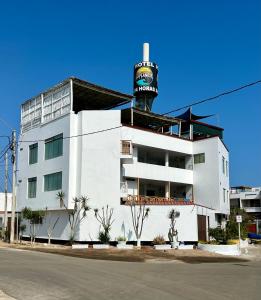 um edifício branco com uma placa no topo em Bravo Surf Camp em Punta Hermosa
