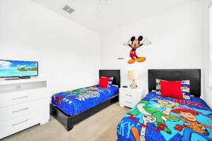 a bedroom with two beds and a flat screen tv at Upstay Bungalow w BBQ, Private Pool - By Disney in Davenport
