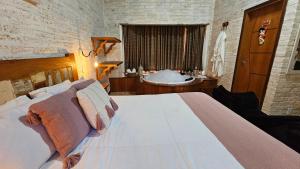 um quarto com uma cama grande e uma banheira em Chalé Gosto da Roça em Monte Verde