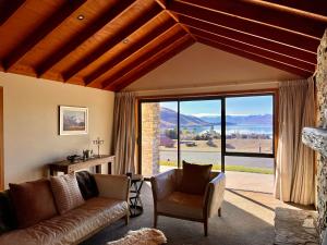 a living room with a couch and a large window at Lake Lodge - Lake Tekapo in Lake Tekapo