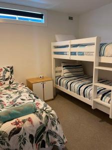a bedroom with two bunk beds and a window at Beach Getaway in Mount Maunganui