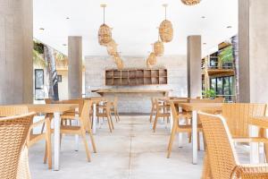 ein Restaurant mit Holztischen und -stühlen und einem Kamin in der Unterkunft Casa Vela Palafito en playa con alberca in La Manzanilla