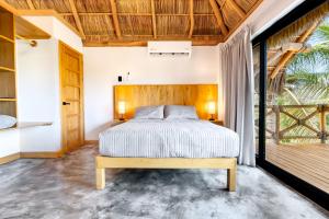 ein Schlafzimmer mit einem Bett und einem hölzernen Kopfteil in der Unterkunft Casa Vela Palafito en playa con alberca in La Manzanilla