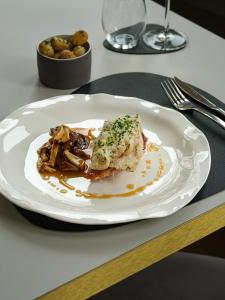 a white plate with food on a table at Hotel-Restaurant Beim Schlass in Wiltz