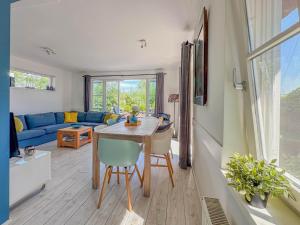 een woonkamer met een tafel en een blauwe bank bij Zwaan 24-7 in Breukelen