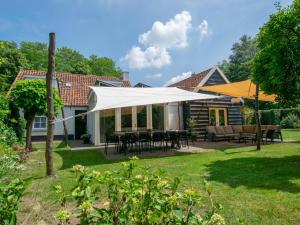 een patio met een witte luifel in een tuin bij Hemels Helleke 2 in Oosterhout