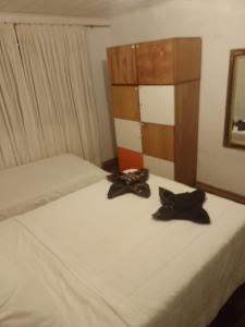 a bed with two pairs of shoes sitting on it at Casa da Cris in Campos do Jordão