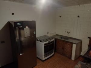 a small kitchen with a stove and a refrigerator at Casa da Cris in Campos do Jordão