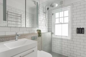 Un baño blanco con lavabo y espejo. en Bondi Junction Apartments by Urban Rest, en Sídney 20 fotos más