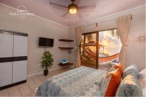 a bedroom with a bed and a tv and a window at Mar y Sombra Villas in Quepos
