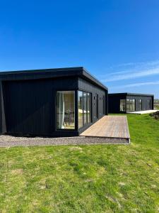 a black house with a wooden deck at REY Stays - House in Höfn