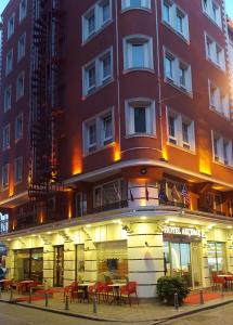 ein großes rotes Gebäude mit Tischen davor in der Unterkunft Hotel Akcinar in Istanbul