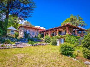a house on a hill with a yard at El Solar de los Pájaros in Merlo