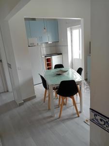 Una cocina con una mesa y sillas en una habitación. en Carolina do Mar, en Nazaré 6 fotos más