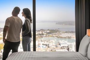 Ein Mann und eine Frau stehen vor einem Fenster in der Unterkunft voco Auckland City Centre, an IHG Hotel in Auckland