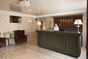 uma mulher de pé na recepção no átrio do hotel em Time Hotel em Kiev