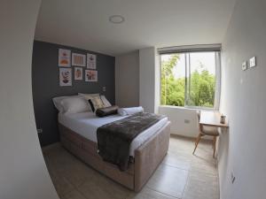 a bedroom with a large bed and a window at Descanso cafetero in Circasia