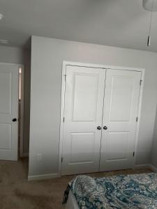 a bedroom with two white doors and a bed at QuickRoute Comfort Relax Living in McDonough