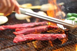 trois morceaux de viande préparés sur un grill dans l'établissement International Resort Hotel Yurakujo, à Narita