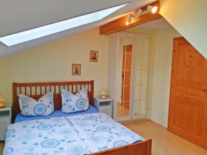 Un dormitorio con una cama con almohadas azules y blancas. en Dwingelo-Lütten Angela Brandstätter Hof | Chiemgau Karte, en Grassau