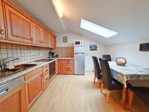 Una cocina con gabinetes de madera y una mesa con sillas. en Dwingelo-Lütten Angela Brandstätter Hof | Chiemgau Karte, en Grassau