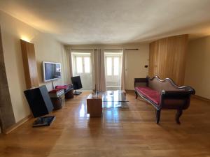 ein Wohnzimmer mit Sofa und Fernseher in der Unterkunft Casa dos Capitães Mores - Vila Flor in Vila Flor